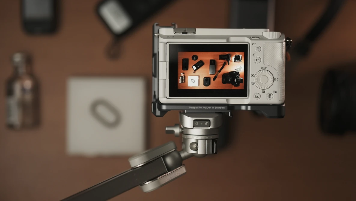 Compact camera mounted on a tripod displaying an overhead flat lay composition on its rear screen.