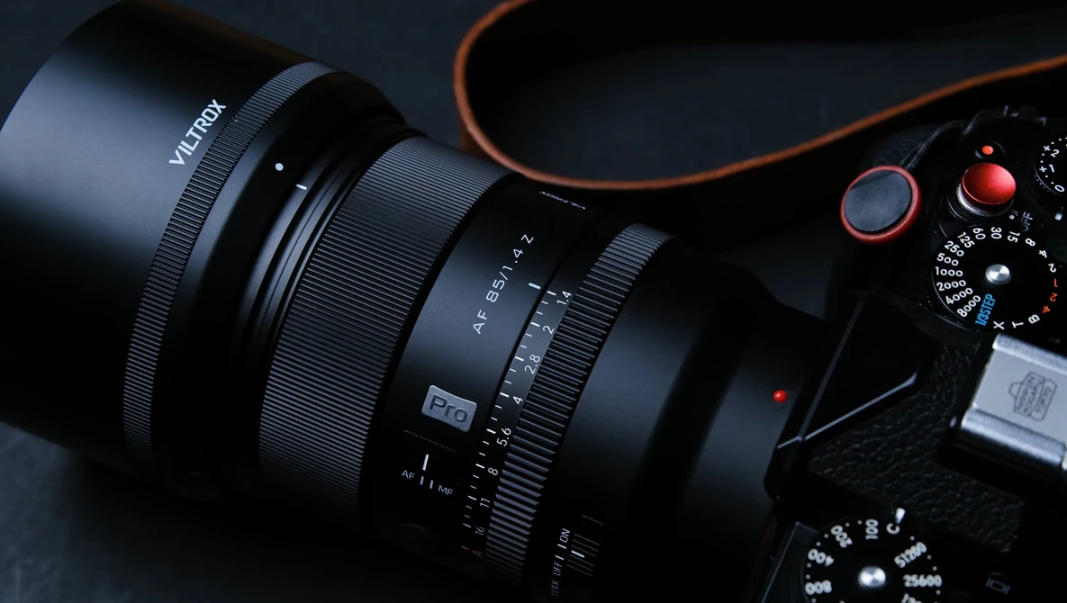Vitkor zoom lens attached to camera body with orange accents against dark background.