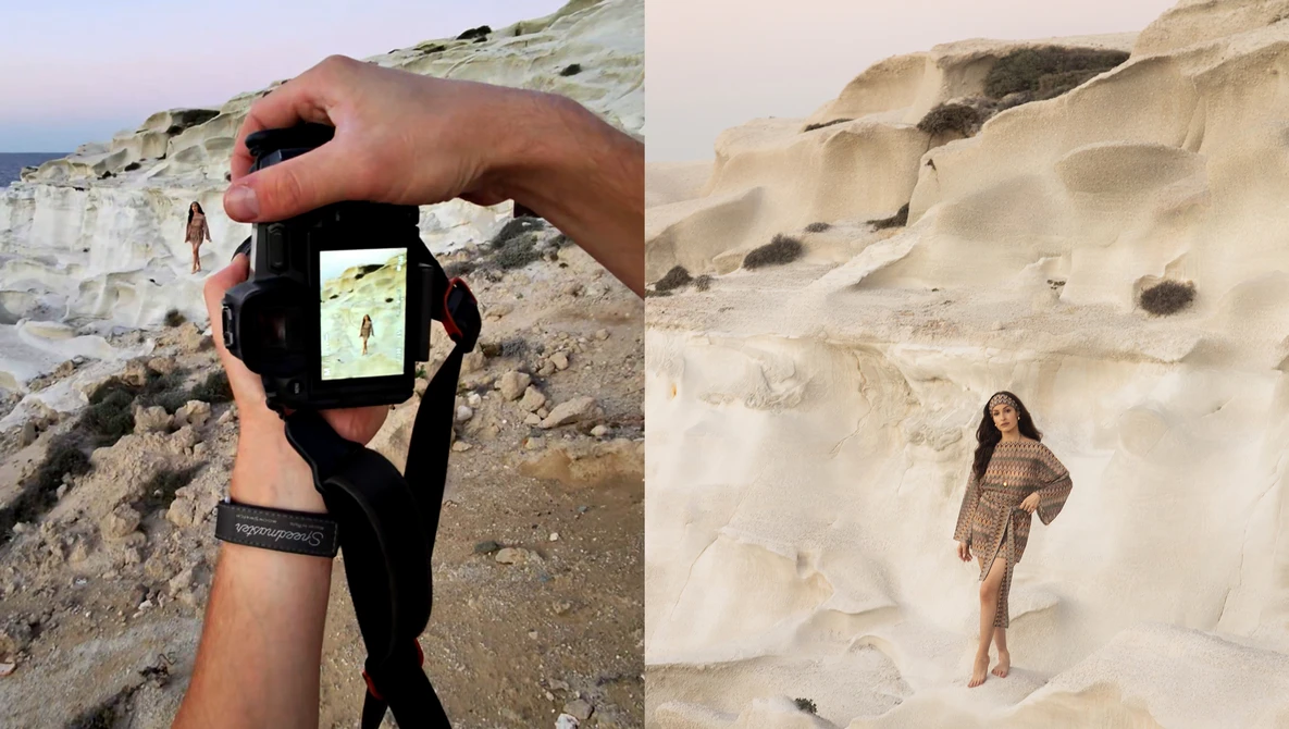 Photographer's hand holding smartphone displaying landscape composition against chalk cliffs and sandy beach.