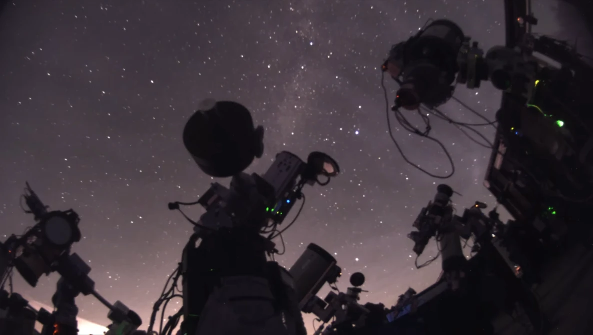 Film and television camera equipment silhouetted against a starry night sky.