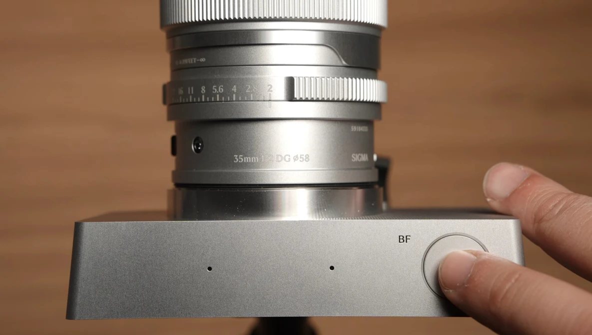 Vintage rangefinder camera with 35mm lens mounted on focusing rail, showing mechanical focus mechanism and manual controls.