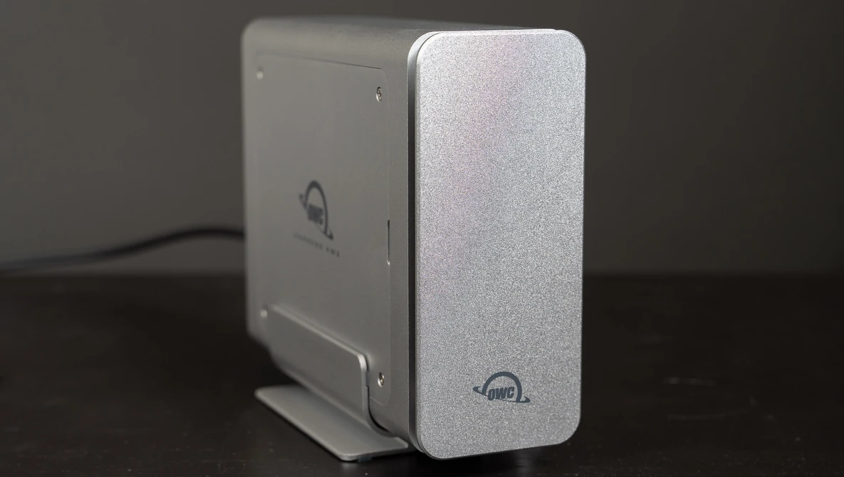 Two external hard drives with silver aluminum enclosures positioned side by side on a dark surface.