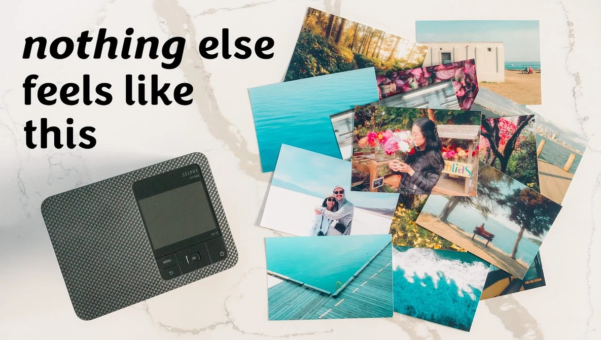 Portable instant photo printer next to scattered printed photographs with travel and nature subjects.