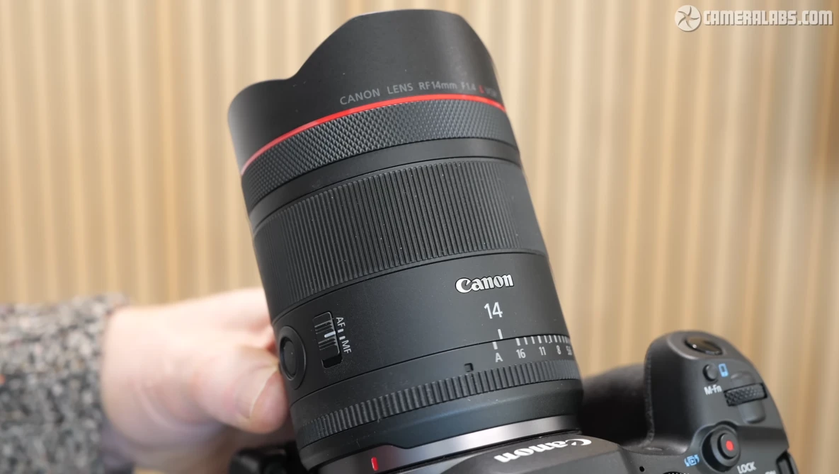 Canon RF 14mm f/1.4L USM lens held in hand during product demonstration.