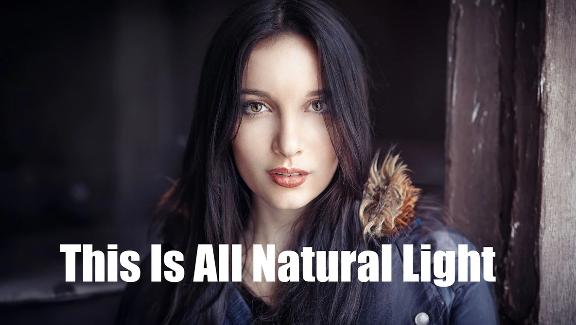 Woman with long dark hair against a dark wooden background, looking directly at camera.