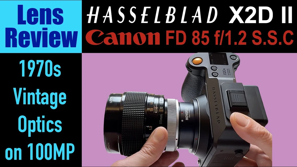 Hasselblad X2D II camera with Canon FD 85mm f/1.2 S.S.C lens mounted, held in hands against pink background.