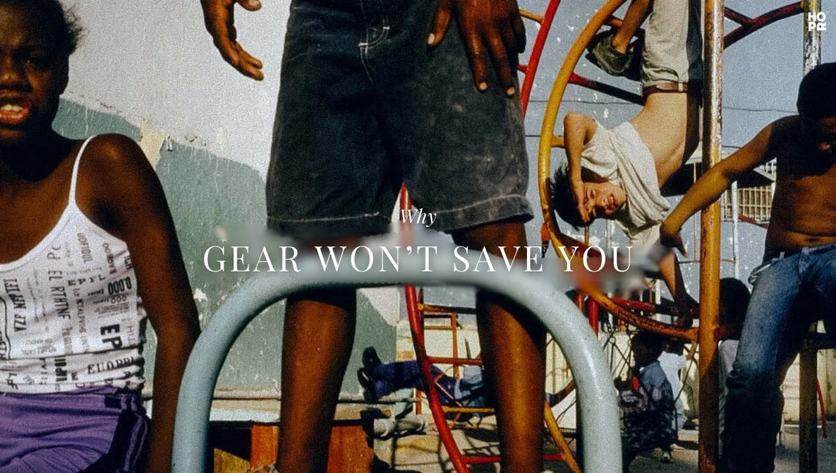 Group of people gathered around playground equipment with overlaid text reading 'GEAR WON'T SAVE YOU.'