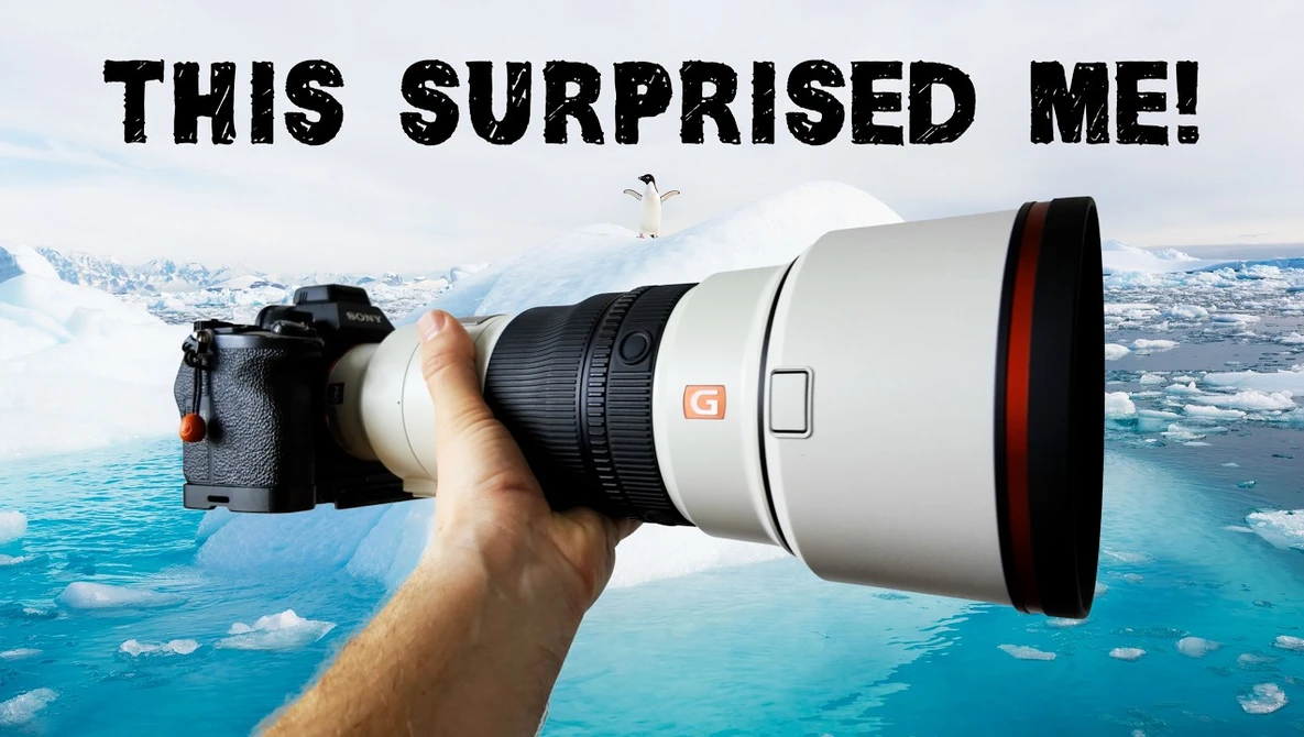 Photographer holding a white telephoto lens with red accents against an aerial landscape of blue water and snowy terrain.