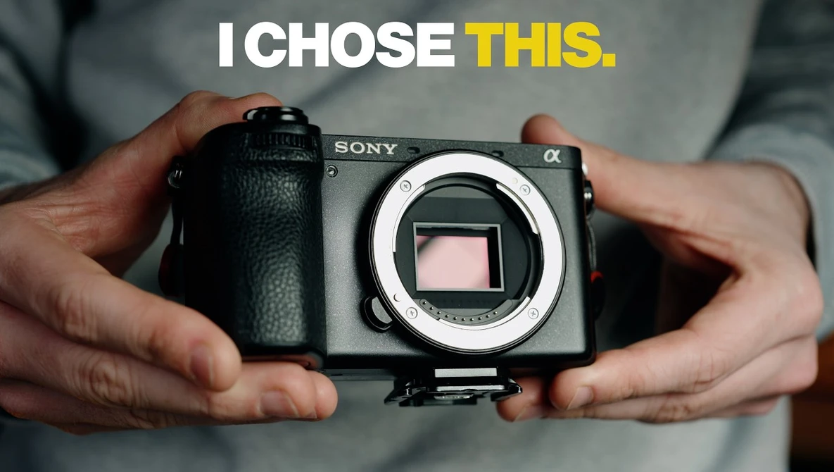 Sony Alpha mirrorless camera body held in hands, showing the sensor and lens mount.