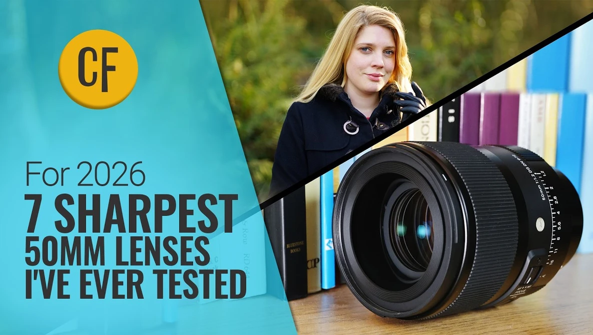 Woman holding a 50mm camera lens with colorful books blurred in the background.