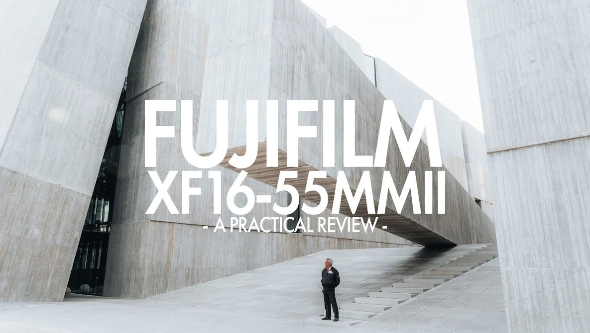 Title card for Fujifilm XF16-55mm II lens review overlaid on modern architecture with lone figure.