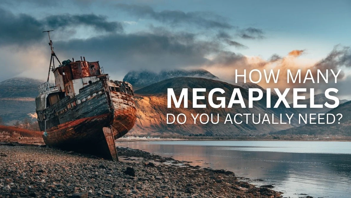 Shipwreck beached on rocky shore with mountains in background and text overlay about megapixels.
