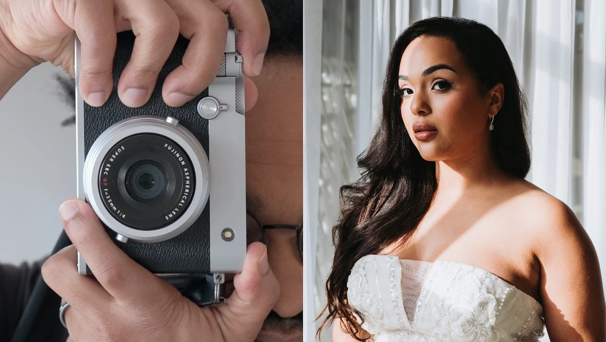 Hands holding a compact rangefinder camera with leather strap and fixed lens.
