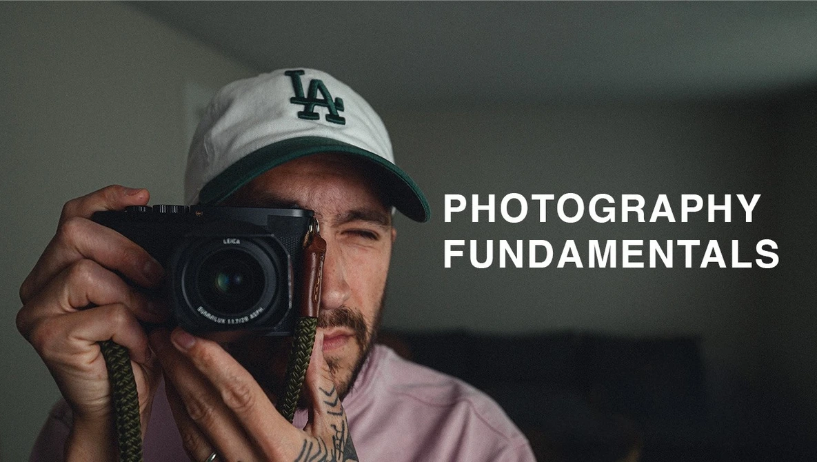 Photographer holding a Leica rangefinder camera, wearing LA Dodgers cap
