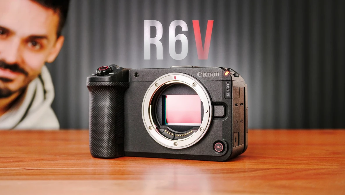 Canon R6V mirrorless camera displayed on wooden surface with portrait in background