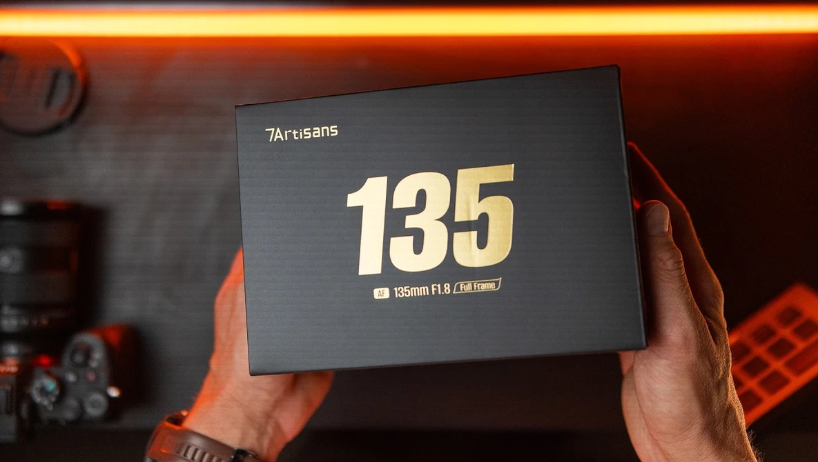7Artisans 135mm F1.8 lens packaging being held up, displaying the lens specifications on the box