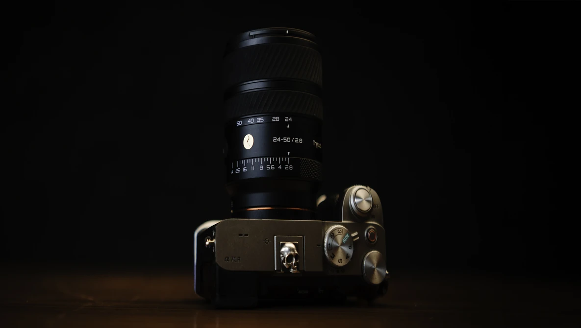 Vintage film SLR camera with telephoto lens against black background, studio lighting