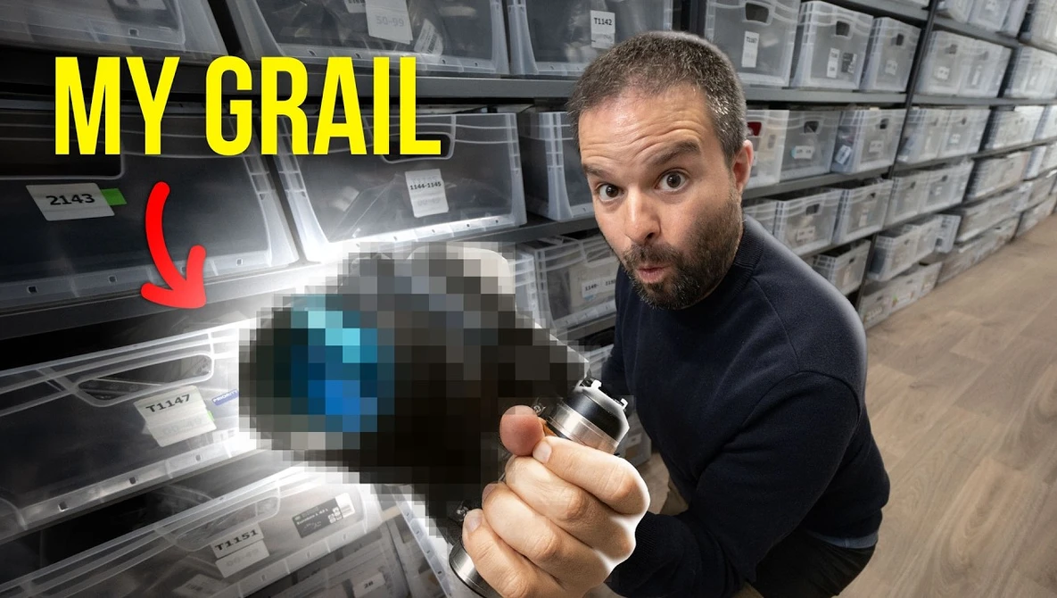 Photographer holding a pixelated camera in a warehouse full of photography equipment boxes