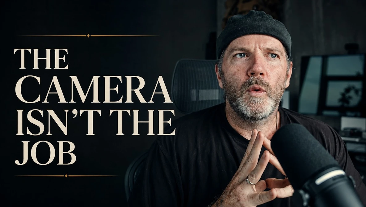 Man in dark clothing and beanie speaking passionately with text overlay reading 'THE CAMERA ISN'T THE JOB'
