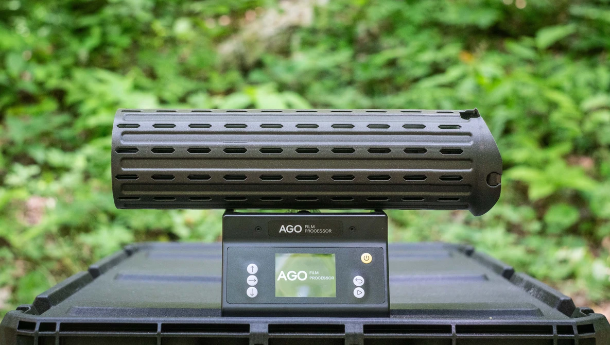 AGO gun rail system mounted on black tactical handguard with green foliage background