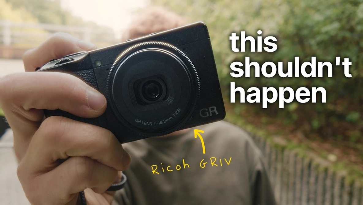 Hand holding a Ricoh GrIV compact digital camera with yellow annotation pointing to the camera body