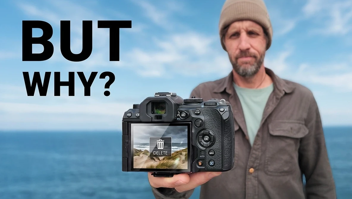 Man holding mirrorless camera displaying landscape scene on rear LCD screen