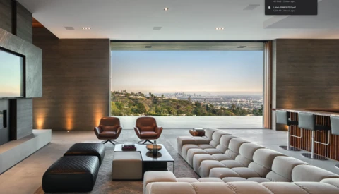 Modern living room with panoramic city view through floor-to-ceiling windows, featuring sculptural furniture and minimalist décor.