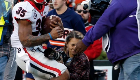 Kneeling Photographer Knocked Unconscious After Sideline Collision at Football Game