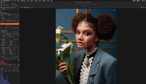 Portrait of a person with voluminous natural hair holding white flowers against a blue and orange background.