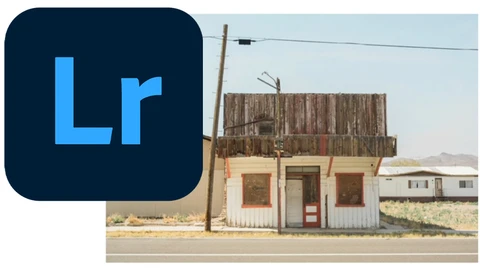 Abandoned roadside building with weathered wooden upper structure and faded storefront in desert landscape.