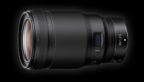 Telephoto zoom lens with electronic focus ring and aperture controls against dark background.