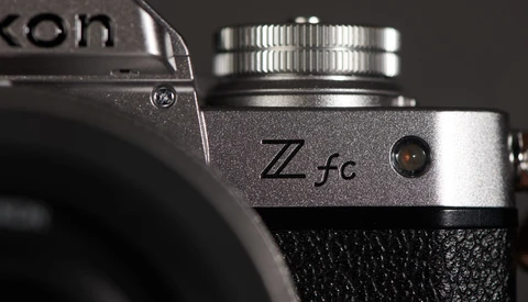 Close-up detail of a Nikon Zfc camera body showing the silver top plate with Zfc designation and control dial.