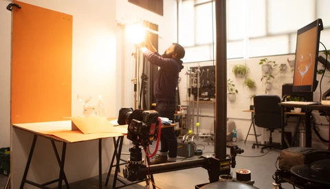 Professional photography studio setup with soft box lighting, tripod-mounted camera, and backdrop system.