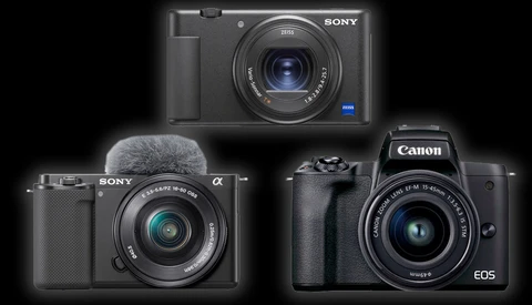 Three digital cameras displayed against a black background: a Sony compact camera at top, a Sony mirrorless camera with microphone at bottom left, and a Canon EOS mirrorless camera at bottom right.