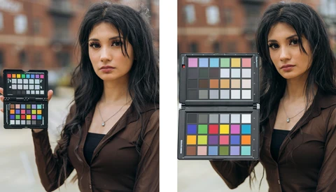 Photographer holding color reference charts during outdoor portrait shoot with brick building backdrop.