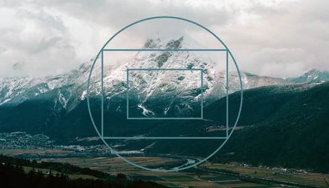 Nested geometric frames overlaid on a snow-capped mountain valley landscape with forested slopes.