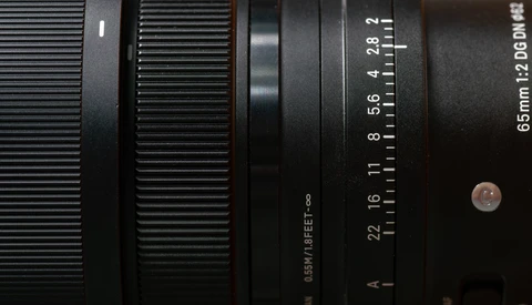 Close-up view of a camera lens barrel showing aperture markings and focal length scale.