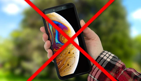 Smartphone displaying a colorful abstract image, marked with a red X symbol indicating prohibition or rejection.