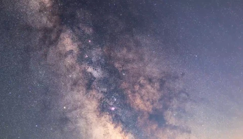 Milky Way galaxy stretching diagonally across a starry night sky with dust lanes and nebulosity visible.