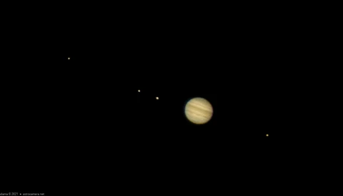Jupiter with visible cloud bands and storm systems against a starfield background.