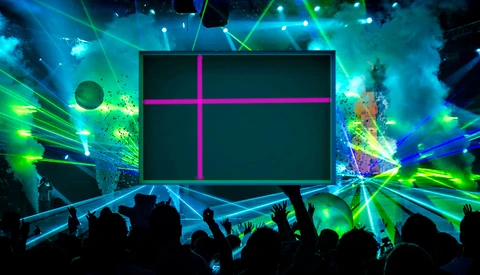 Large stage screen with magenta cross pattern during concert with silhouetted crowd and vibrant cyan and green laser lighting.
