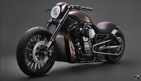 Custom cruiser motorcycle with extended fork, chrome headlight, and wide whitewall tires on neutral background.