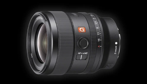 Sony FE 24mm f/1.4 GM prime lens with autofocus ring and aperture scale visible against dark background.