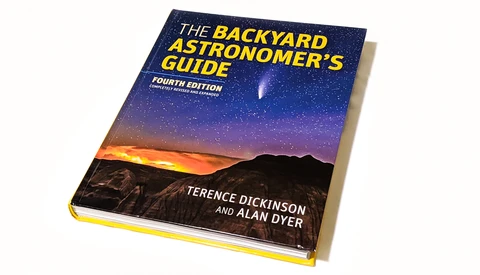 The Backyard Astronomer's Guide fourth edition book cover with night sky gradient and mountain silhouette.