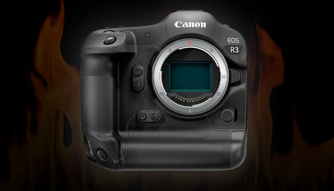 Canon EOS R3 mirrorless camera body with exposed sensor mount, photographed against dark background with warm lighting.