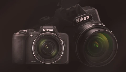 Two Nikon COOLPIX cameras displayed side-by-side against a dark background with studio lighting.