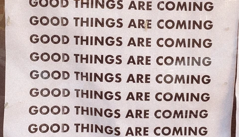 Repeated text reading "GOOD THINGS ARE COMING" printed in brown typography on a light background.
