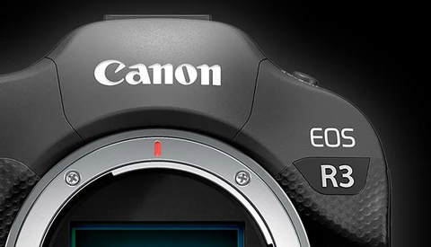 Canon EOS R3 mirrorless camera body viewed from above, showing the lens mount and top surface with branding.