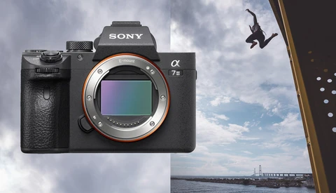 Sony α7 III mirrorless camera with sensor visible, composite showing aerial performer and waterfront cityscape.