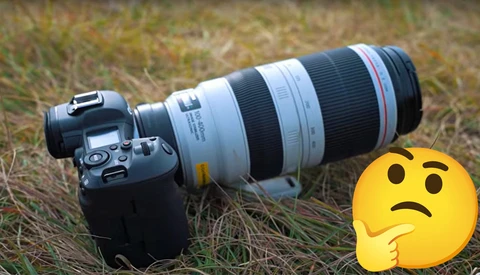DSLR camera with telephoto zoom lens mounted on grass, alongside a confused emoji symbol.